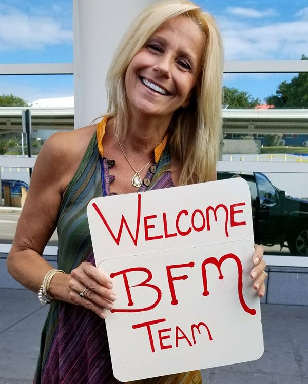 Bonnie-holding-Welcome-sign-for-Mission-Team